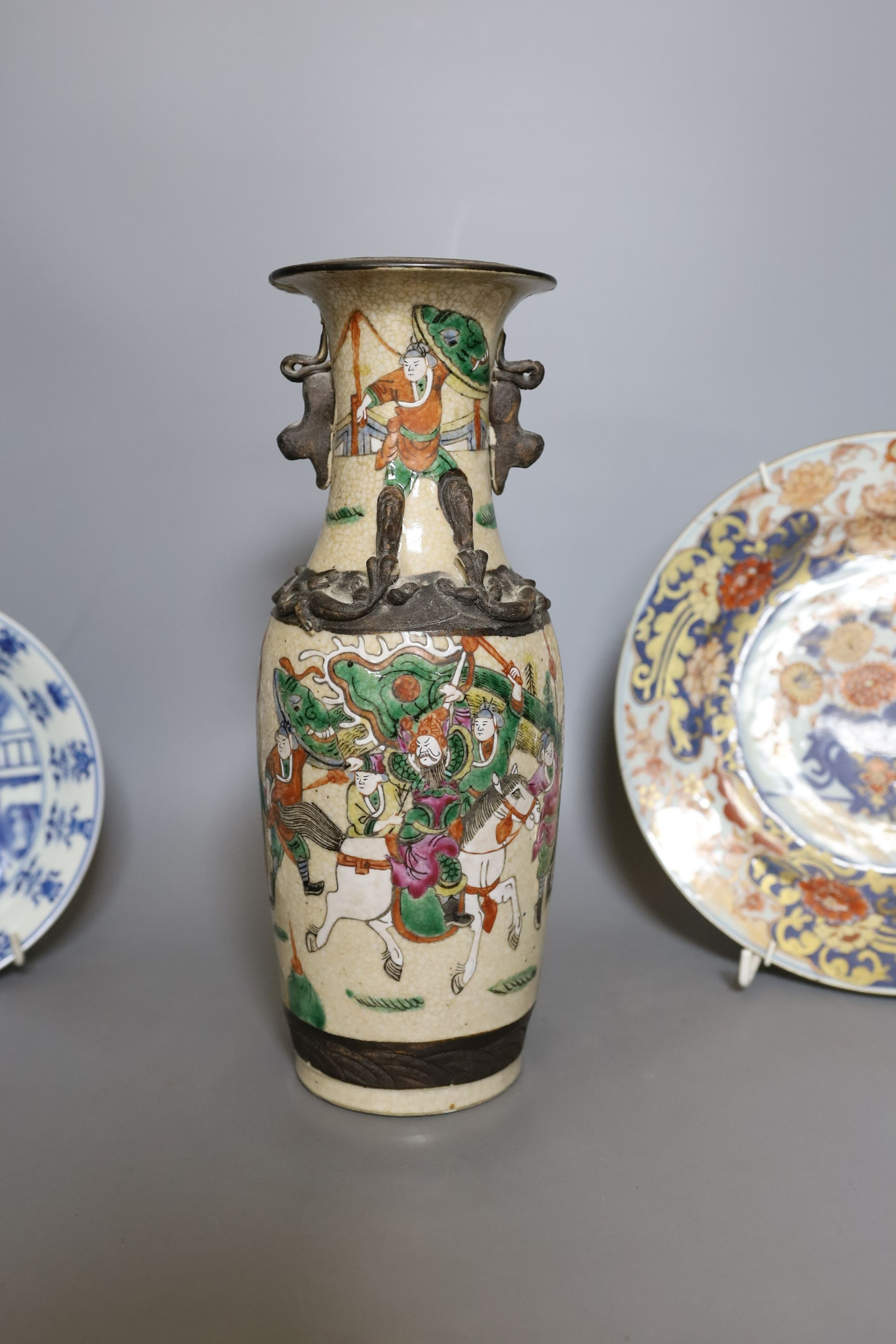 Three Chinese plates including a 19th century Chinese Imari dish, 23cm - repaired, a Chinese famille rose crackleglaze vase, 29cm, together with a famille rose teapot and a crackleglaze celadon ground bottle vase. Talles